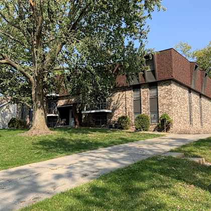 a large brick building with a tree in front of it