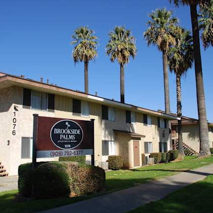 a building with a sign that says brookside palms in front of it.