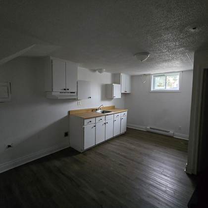 a kitchen with white cabinets and a wooden countertop.