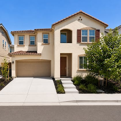 a beige house with a brown garage door and a brown window.