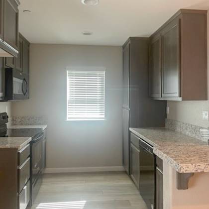 a kitchen with brown cabinets and granite countertops.