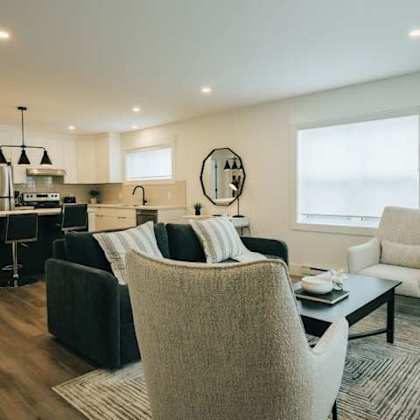 a modern living room with a kitchen area in the background.