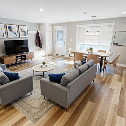 a living room with a grey couch and a wooden floor.