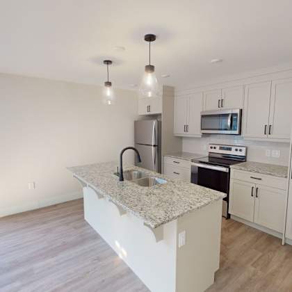 a kitchen with white cabinets and a granite countertop.