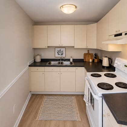 a kitchen with white appliances and wooden floors.