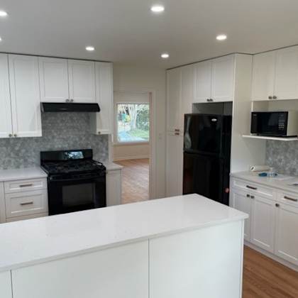 a kitchen with white cabinets and a black stove top oven.