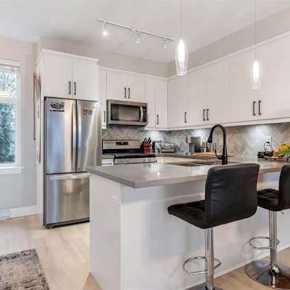 a kitchen with white cabinets and a black counter.