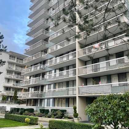 a tall residential building with balconies and windows.