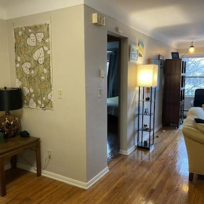 a living room with a couch, a lamp, and a painting on the wall.