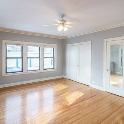 a room with a ceiling fan and wooden floors.