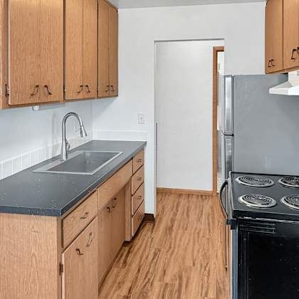 a kitchen with wooden cabinets and a black stove top oven.