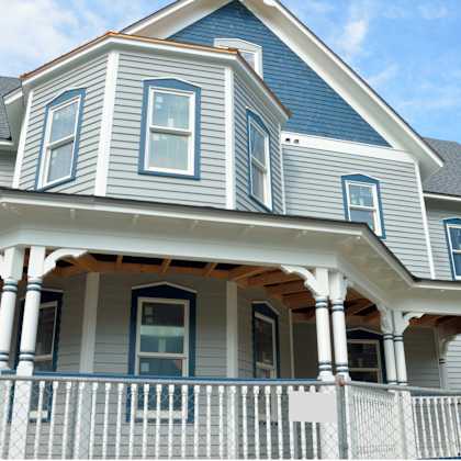 a blue house with white trim and a porch.