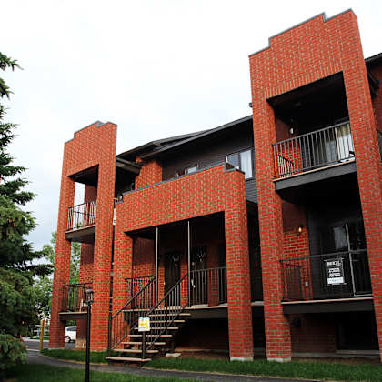 a red brick building with a balcony and stairs.