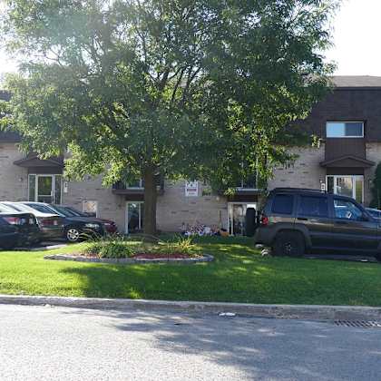 a black car is parked in front of a house.