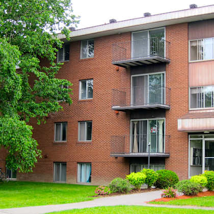 a red brick building with a balcony on the second floor.