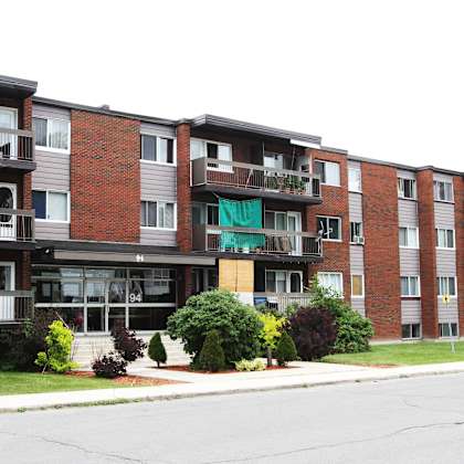 apartment building with a green awning on the second floor.