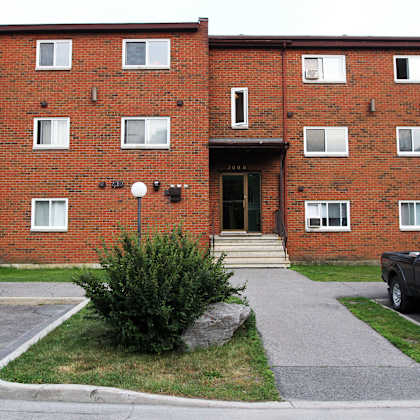 a red brick apartment building with a black truck parked in front.