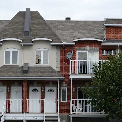a red brick house with a white door and windows.