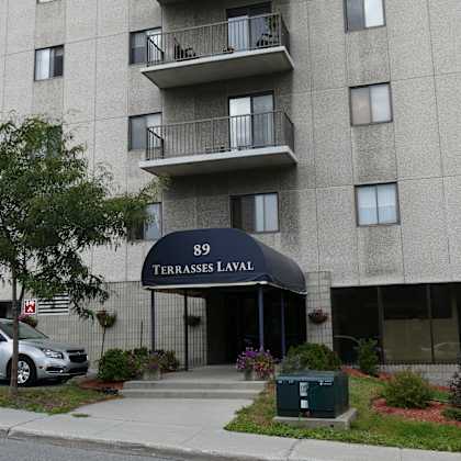 a grey building with a black awning that says terrasses laval.