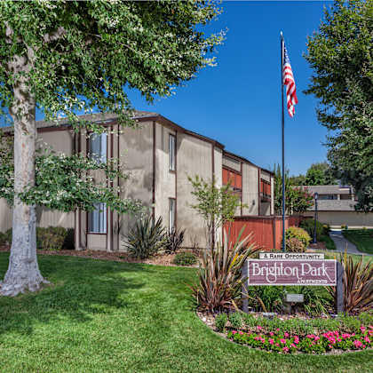 a building with a sign that says "brighton park apartments" in front of it.