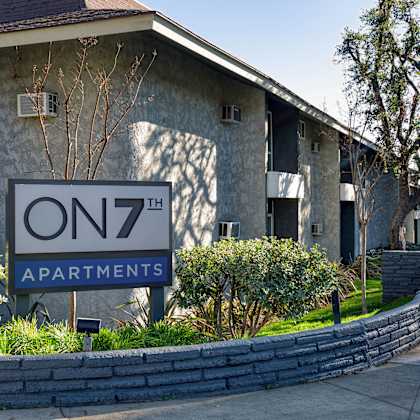 apartment complex with a sign that says "on 7th apartments"