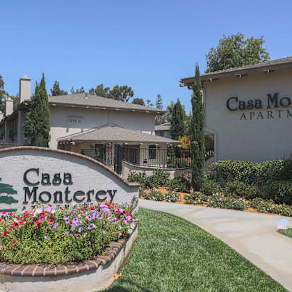 a sign for casa monterey apartments is in front of a building.