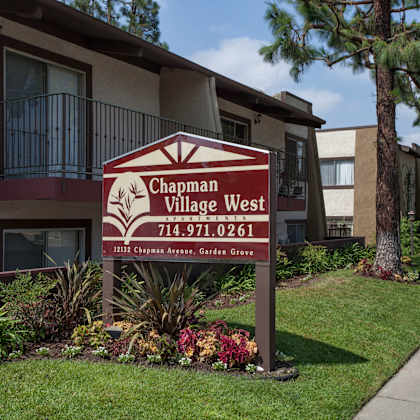 a sign for "chapman village west apartments."