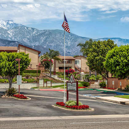 a street view of the apartments with an american flag on a pole next to a sign for "don miguel apartments."