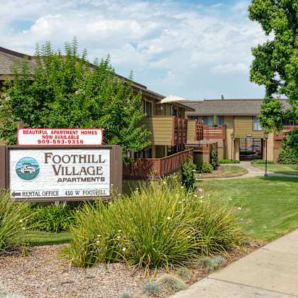 a sign for foothill village apartments is in front of some buildings.