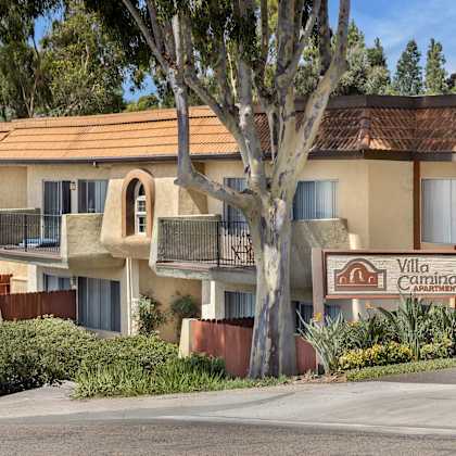 a sign for "villa camino apartments" is in front of a building.