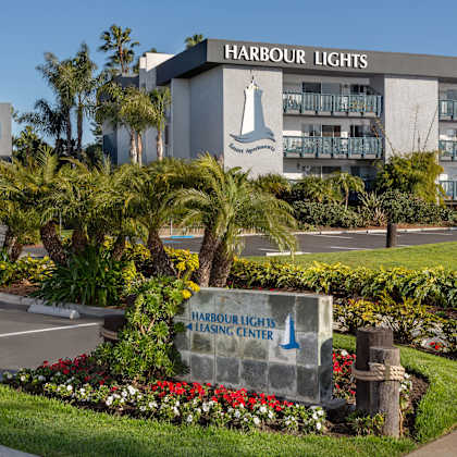 a sign for "harbour lights resort apartments" on the side of the apartment building.