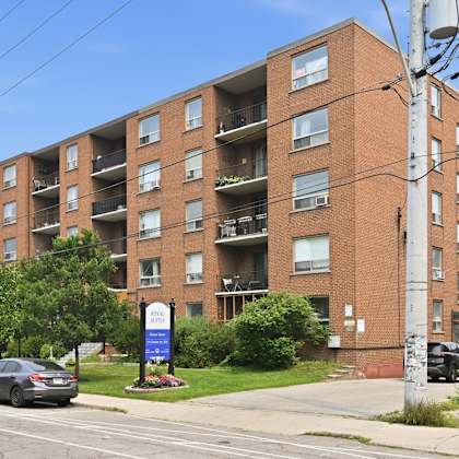 a large brick apartment building with a blue sign in front.