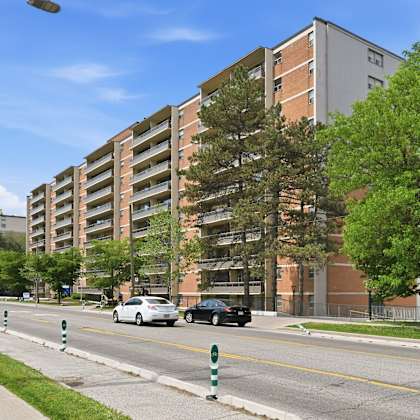 a street with cars and apartment buildings on the side.