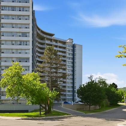 a tall building with a curved design and balconies on the upper floors.
