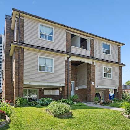 a two-story house with a well-maintained lawn and a small garden in front.