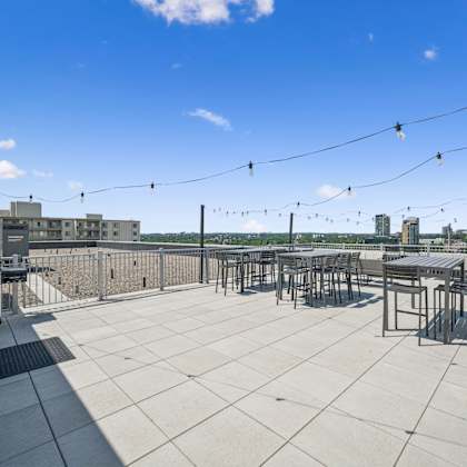 a rooftop patio with a table and chairs overlooking a city skyline.