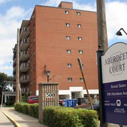 a sign for aberdeen court is in front of a brick building.