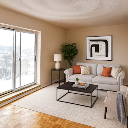 a living room with a white couch, a coffee table, and a large window.