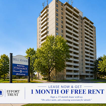 a tall building with a sign in front that says "bell manor" and "1 month of free rent".