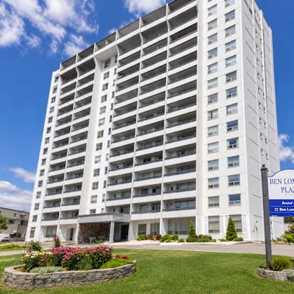 a tall white building with a blue sign in front that says ben lomond plaza.