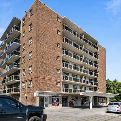 a large brick building with a parking lot in front.