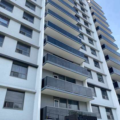 a modern building with a white facade and black balconies.
