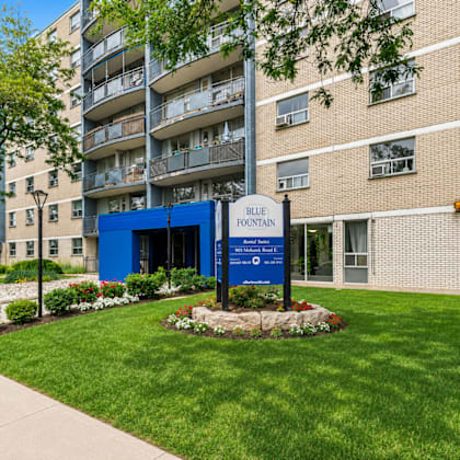 a blue sign in front of a building that says blue fountain.