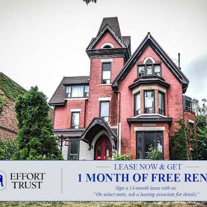 a large red house with a sign offering 1 month free rent.