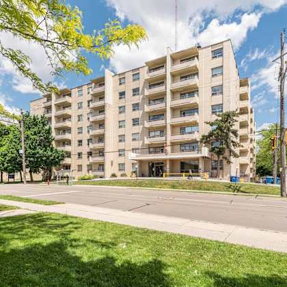 a large apartment building with a grassy area in front.