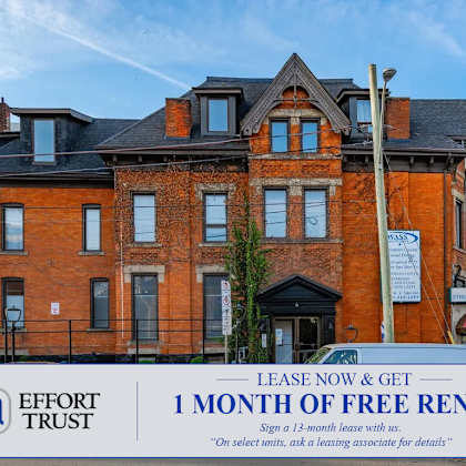 a large brick building with a sign offering a free month of rent.