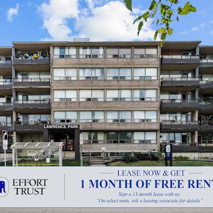 a multi-story apartment building with a sign offering a free month of rent for 13-month leases.
