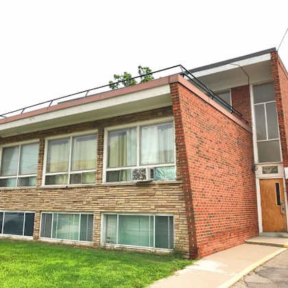 a red brick building with a balcony and a door.
