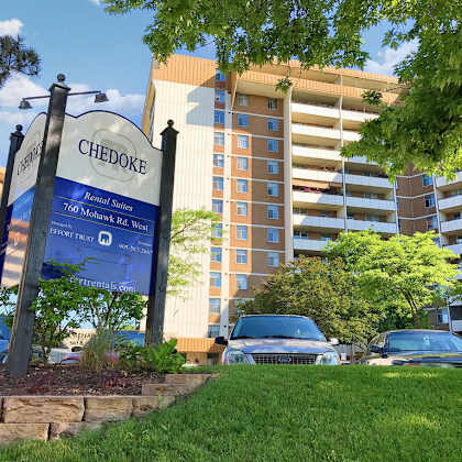 a sign for chedoke apartment homes stands in front of a building.