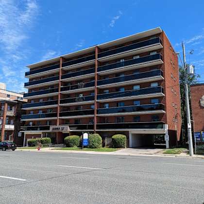 a large red brick building with a parking lot in front.